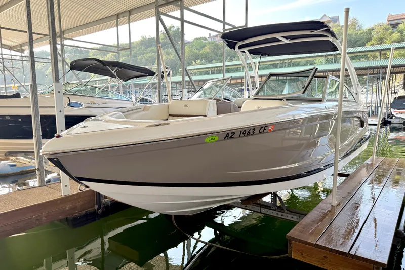 Slide: The Image of 2013 Cobalt A25 boat docked in a marina, featuring sleek design and canopy. - 39
