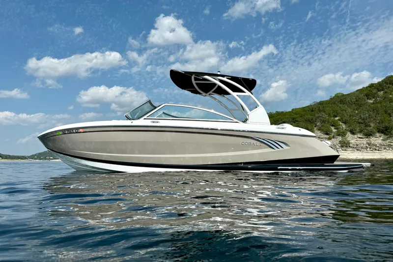 Slide: The Image of 2013 Cobalt A25 boat on calm water under a blue sky with clouds. - 9