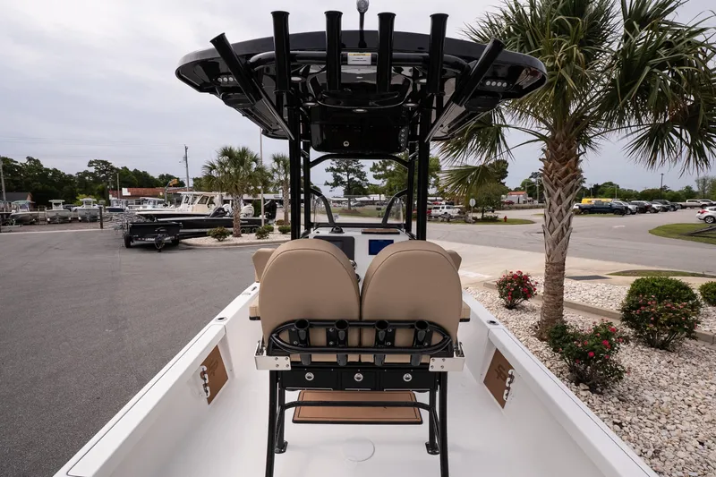 Slide: The Image of 2026 Sea Pro 230 Bay boat interior with seating and console, parked near palm trees. - 7