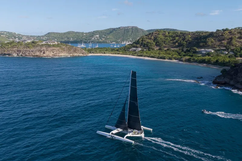 Slide: The Image of Sailing yacht CDK Technologies MOD 70, 2012, cruising near a scenic coastline. - 1