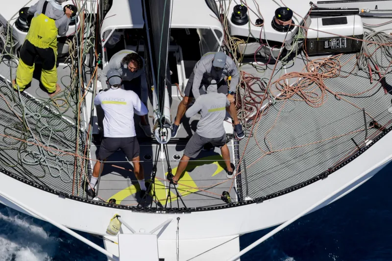 Slide: The Image of Crew working on CDK Technologies MOD 70 sailboat, 2012 model, with ropes and equipment on deck. - 10