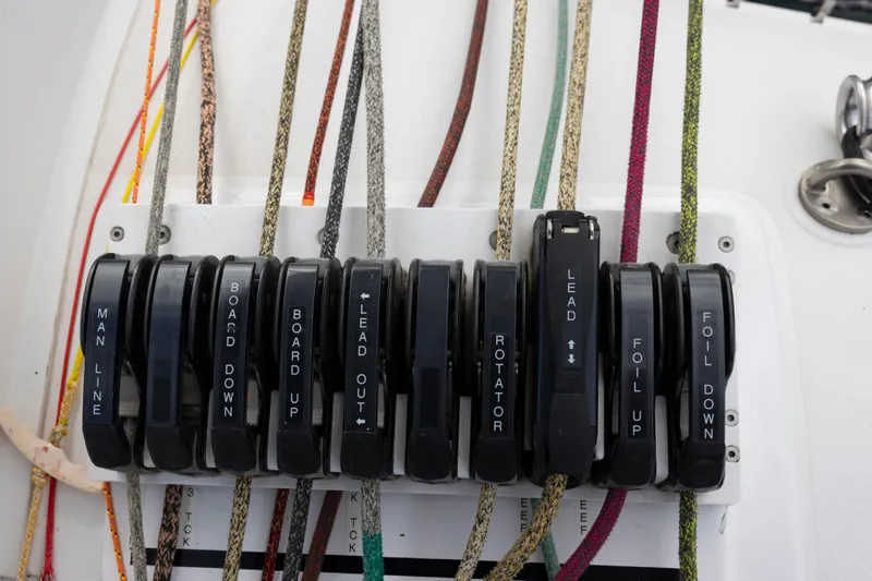 Slide: The Image of Control panel with labeled levers and ropes on a 2012 CDK Technologies MOD 70 sailboat. - 15