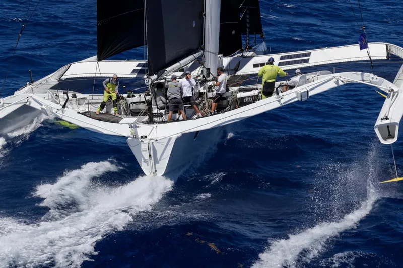 Slide: The Image of Sailing team on CDK Technologies MOD 70 trimaran, 2012, navigating ocean waves. - 2