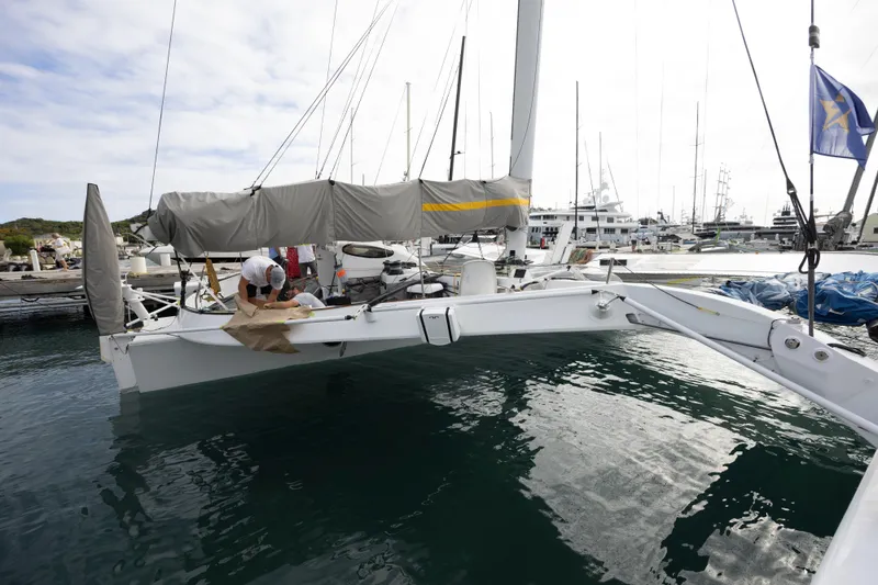 Slide: The Image of Trimaran sailboat CDK Technologies MOD 70, 2012 model, docked at marina with person onboard. - 20