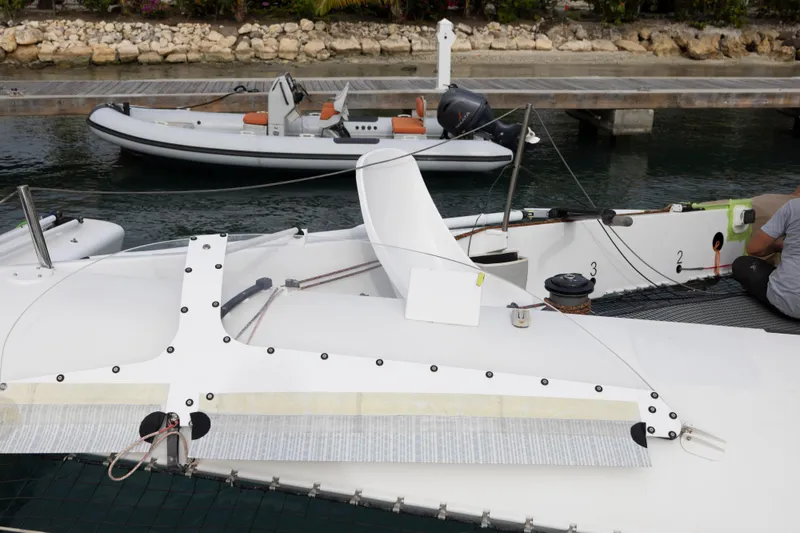 Slide: The Image of CDK Technologies MOD 70 trimaran docked, showcasing sleek design and advanced rigging, 2012 model. - 21
