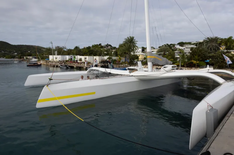 Slide: The Image of 2012 CDK Technologies MOD 70 trimaran docked in a scenic harbor. - 56
