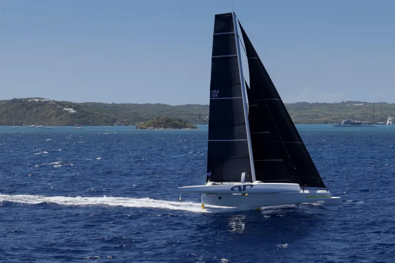 Slide: The Image of Sleek 2012 CDK Technologies MOD 70 sailing on blue ocean near lush islands. - 64
