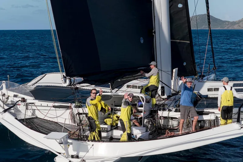 Slide: The Image of Sailors on CDK Technologies MOD 70 trimaran, 2012, navigating ocean waters. - 9