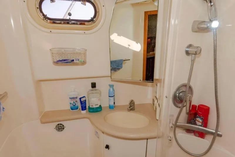 Slide: The Image of 2004 Pursuit 3800 Express boat bathroom with sink, mirror, and showerhead. - 6