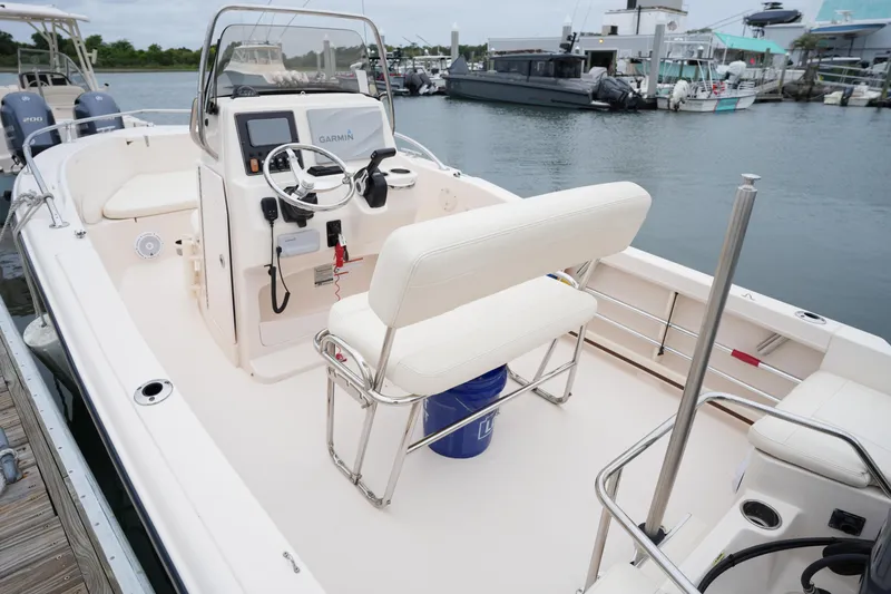 Slide: The Image of 2019 Grady-White Fisherman 180 boat interior at marina, featuring helm and seating. - 13