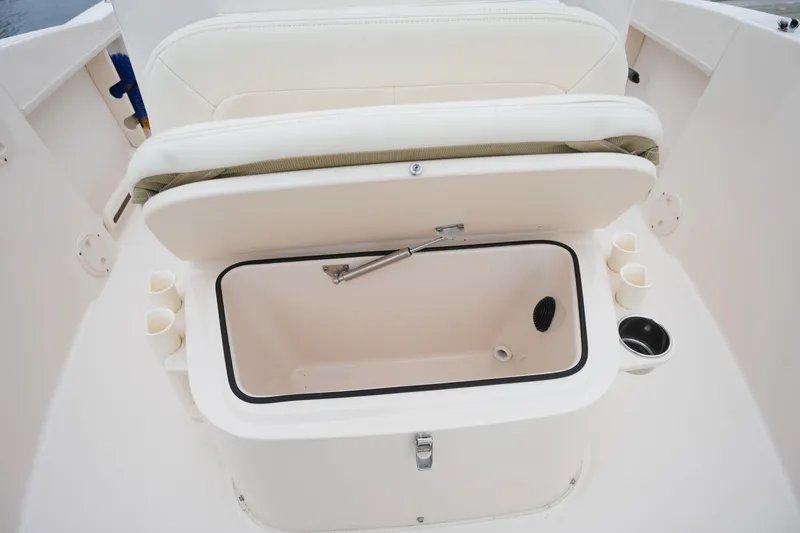 Slide: The Image of 2019 Grady-White Fisherman 180 boat storage compartment with open lid and cup holders. - 22