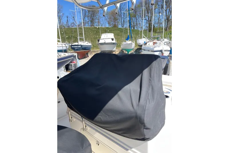 Slide: The Image of 2005 Boston Whaler 320 Outrage boat interior with seating, docked by a serene lake. - 12