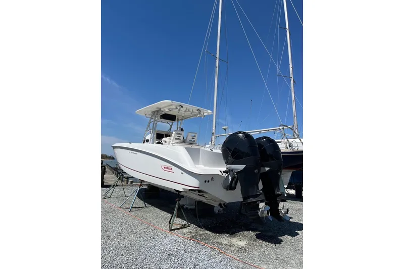 Slide: The Image of 2005 Boston Whaler 320 Outrage boat with T-top and seating, docked outdoors. - 19