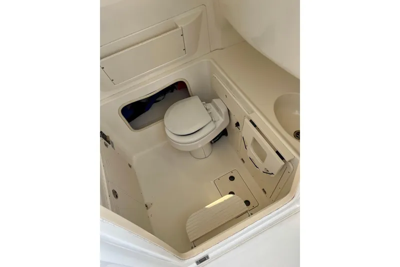 Slide: The Image of 2005 Boston Whaler 320 Outrage boat interior with compact marine toilet and storage. - 32