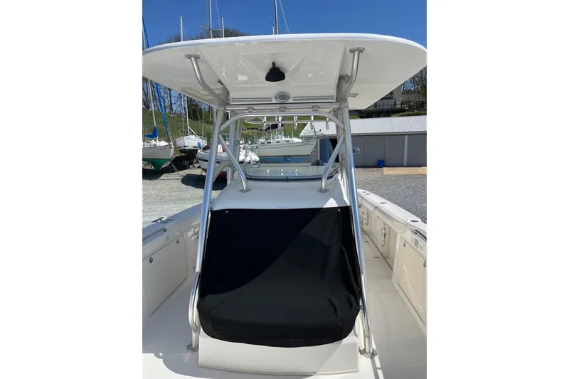 Slide: The Image of 2005 Boston Whaler 320 Outrage boat interior with helm, docked by the water. - 7