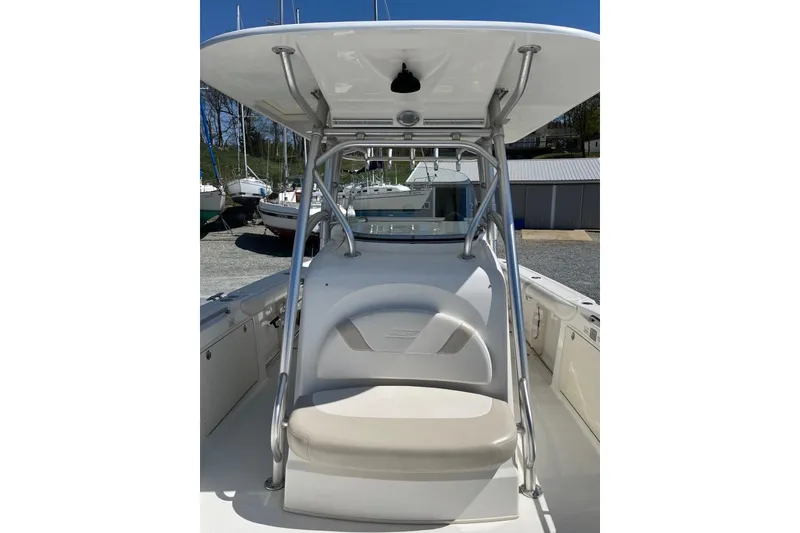 Slide: The Image of 2005 Boston Whaler 320 Outrage boat docked, featuring helm and seating area. - 8