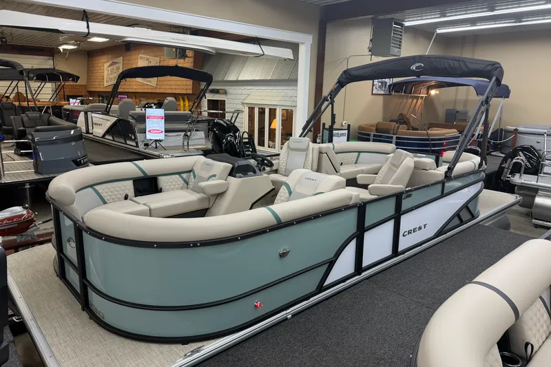 The Image of 2026 Crest Conquest 230 SLC pontoon boat displayed in showroom. - 1