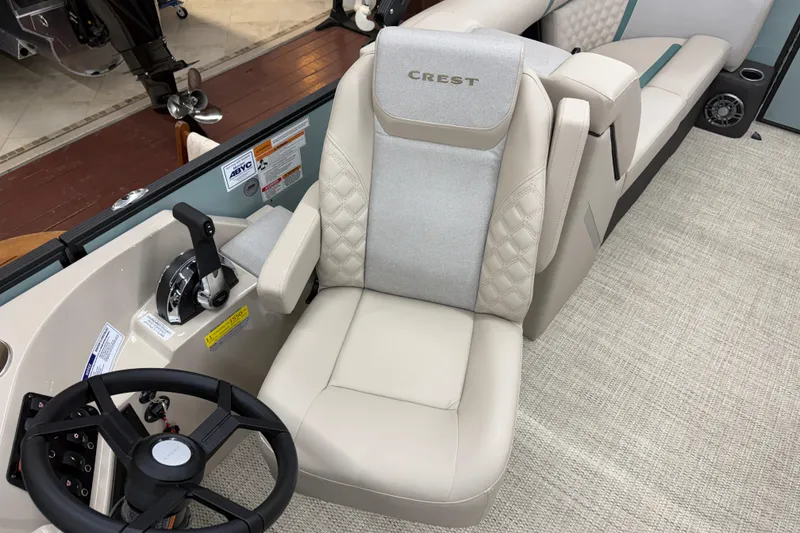 Slide: The Image of Captain's seat of 2026 Crest Conquest 230 SLC boat with steering wheel and controls. - 9