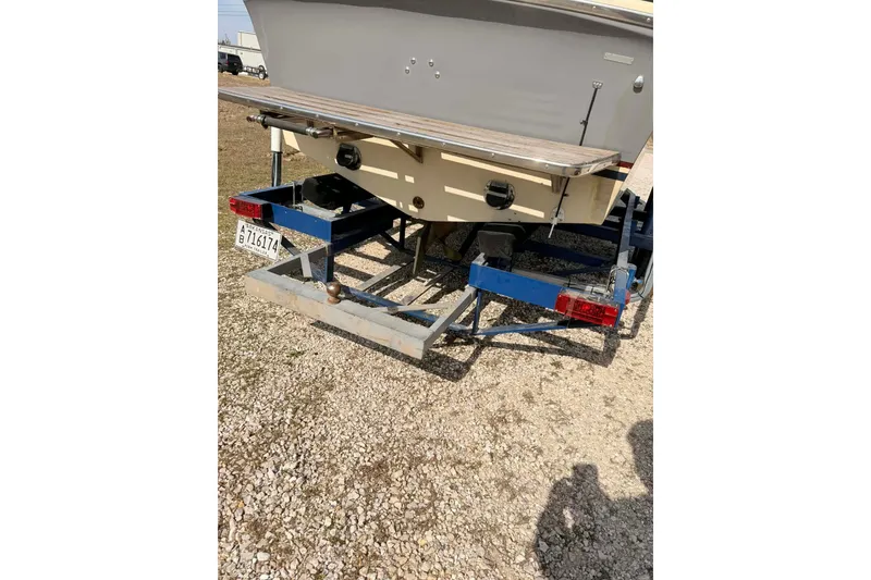 Slide: The Image of 1984 Century Resorter boat on trailer, rear view, parked on gravel. - 11