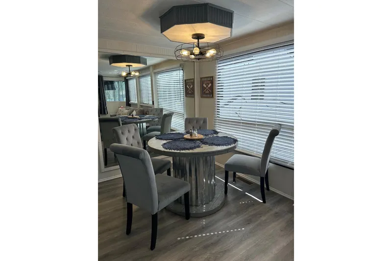 Slide: The Image of Modern dining area in a 1995 Lakeview 15x70, featuring elegant gray chairs and a round table. - 13