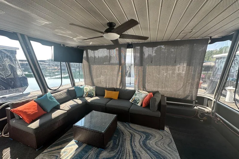 Slide: The Image of Spacious Lakeview 15x70 houseboat interior with cozy seating, colorful cushions, and waterfront view. - 15