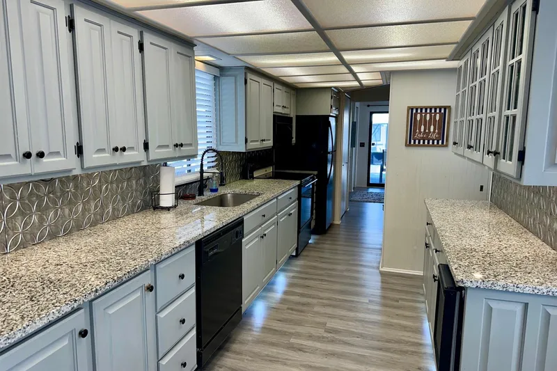Slide: The Image of Spacious kitchen in 1995 Lakeview model, featuring granite countertops and modern appliances. - 16