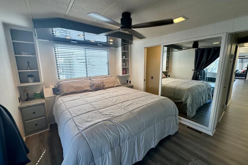 Slide: The Image of Cozy bedroom in 1995 Lakeview 15x70 houseboat with modern decor and mirrored closet. - 6