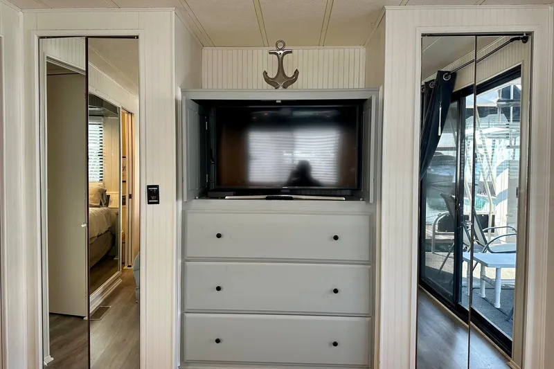 Slide: The Image of Interior of 1995 Lakeview 15x70 houseboat with TV, drawers, and mirrored doors. - 7