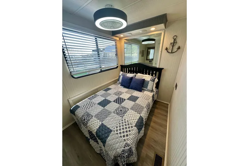 Slide: The Image of Cozy bedroom in 1995 Lakeview 15x70 houseboat with nautical decor and quilted bedding. - 9