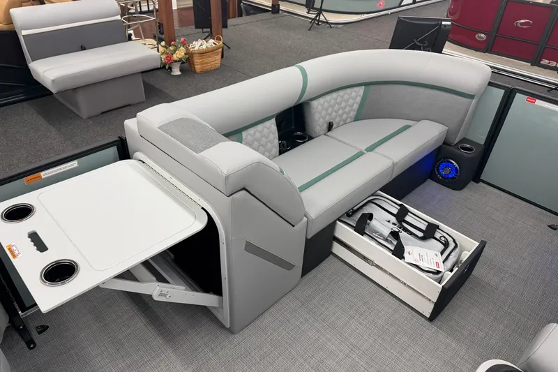 Slide: The Image of 2026 Crest Conquest 230 SLSC boat interior with gray seating, storage, and fold-out table. - 6