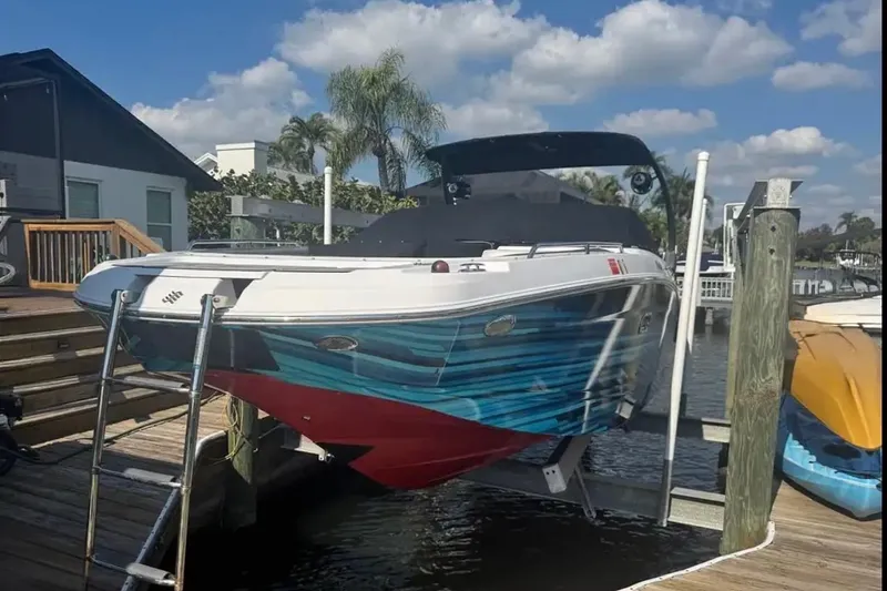 Slide: The Image of 2017 Four Winns HD240 boat docked, featuring a vibrant blue and red hull design. - 3
