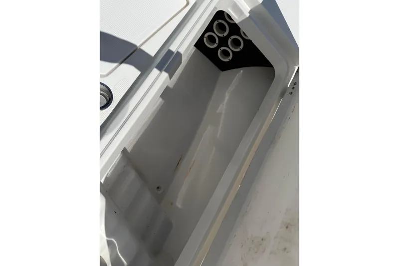 Slide: The Image of Storage compartment of 2019 Aquasport 224 Bay boat, featuring rod holders. - 18
