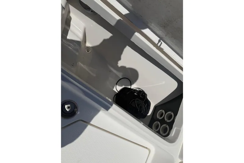 Slide: The Image of 2019 Aquasport 224 Bay boat storage compartment with wiring and cup holders. - 19