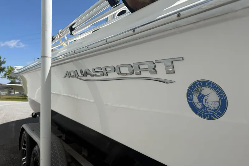 Slide: The Image of 2019 Aquasport 224 Bay boat with Palm City Yachts logo, parked on a trailer. - 6
