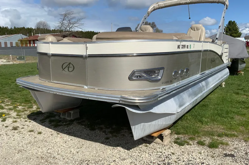 The Image of 2018 Avalon 2385 QL pontoon boat on grass, showcasing sleek design and comfortable seating. - 1