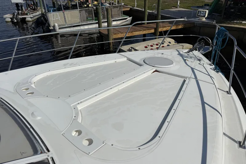 Slide: The Image of 2002 Cruisers Yachts 4450 Express Motoryacht docked, showcasing spacious deck and sleek design. - 12