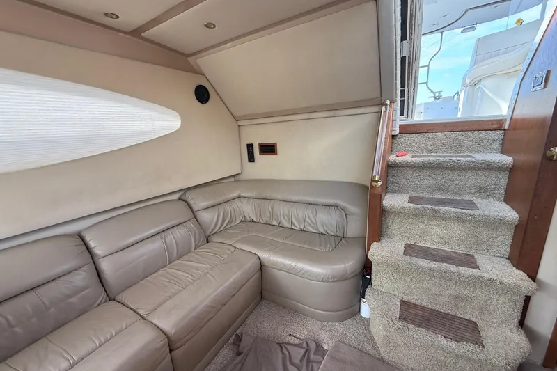 Slide: The Image of 2002 Cruisers Yachts 4450 Express Motoryacht interior with beige leather seating and carpeted stairs. - 29
