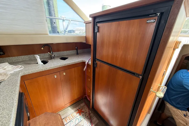Slide: The Image of 2002 Cruisers Yachts 4450 Express Motoryacht kitchen with wood cabinets and countertop. - 39