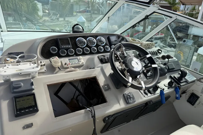 Slide: The Image of 2002 Cruisers Yachts 4450 Express Motoryacht helm with steering wheel and control panel. - 43
