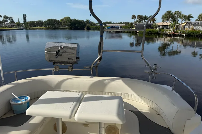 Slide: The Image of 2002 Cruisers Yachts 4450 Express Motoryacht with seating and grill by a serene lake. - 44