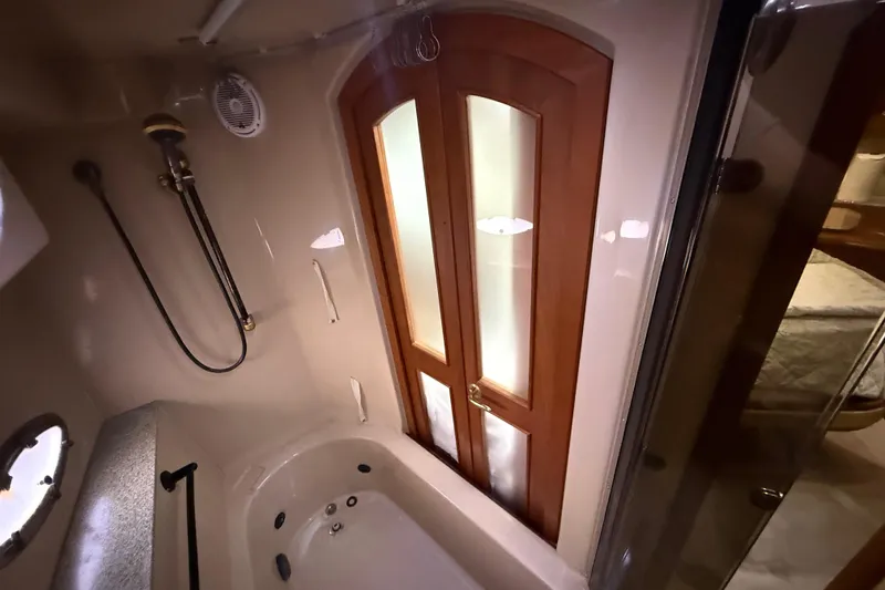 Slide: The Image of Luxurious bathroom in 2002 Cruisers Yachts 4450 Express Motoryacht with wooden doors and jacuzzi tub. - 50