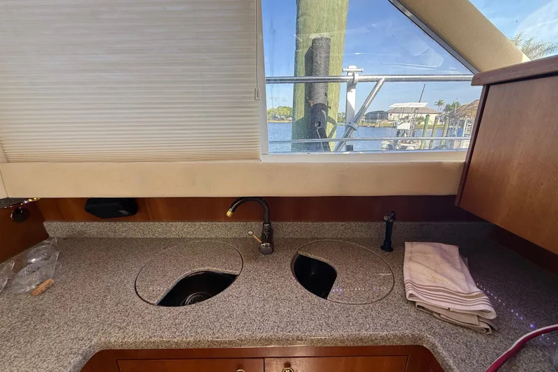 Slide: The Image of 2002 Cruisers Yachts 4450 Express Motoryacht kitchen with granite countertop and window view. - 58