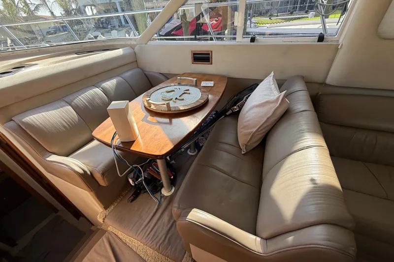 Slide: The Image of Interior of 2002 Cruisers Yachts 4450 Express Motoryacht with leather seating and wooden table. - 61