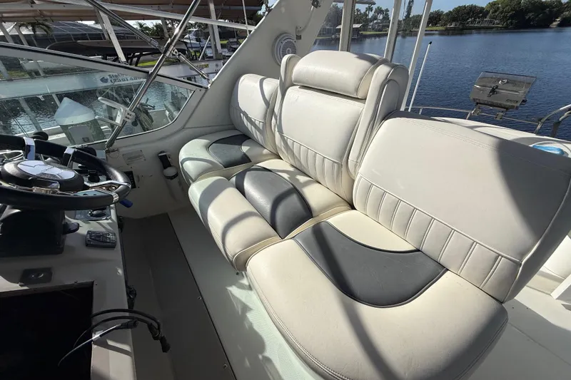 Slide: The Image of 2002 Cruisers Yachts 4450 Express Motoryacht helm with plush seating and steering wheel. - 64