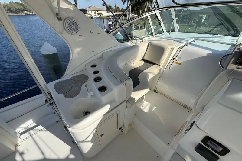 Slide: The Image of 2002 Cruisers Yachts 4450 Express Motoryacht interior with seating and sink, docked by water. - 69
