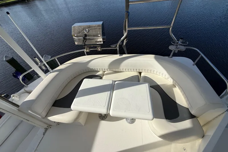 Slide: The Image of 2002 Cruisers Yachts 4450 Express Motoryacht with white seating and table on deck. - 71