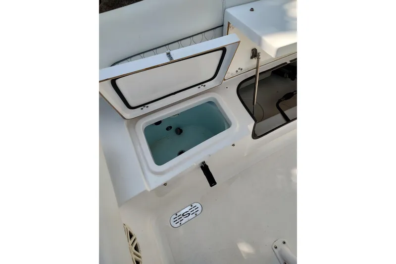 Slide: The Image of 2020 Sportsman Heritage 211 Center Console boat interior with open storage compartment. - 21
