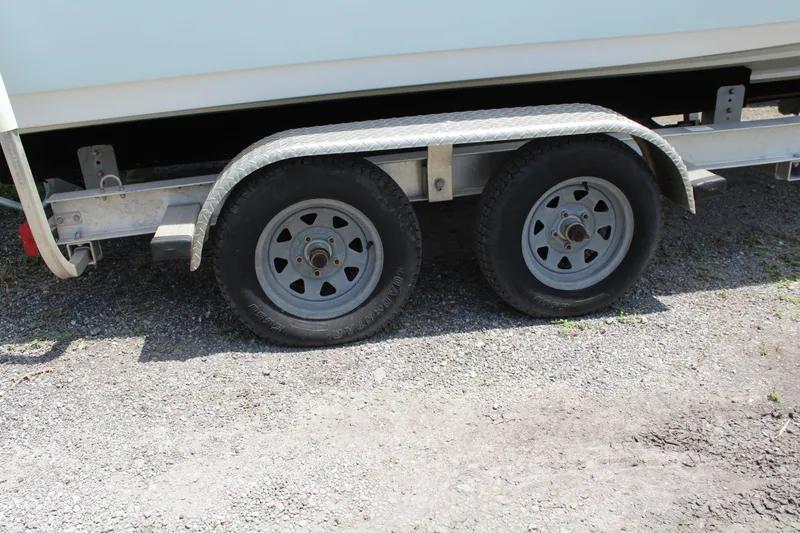 Slide: The Image of Trailer wheels of a 2020 Sportsman Heritage 211 Center Console boat on gravel. - 47