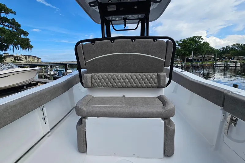 Slide: The Image of 2026 Sea Hunt Ultra 245 SE boat interior with cushioned seating and scenic marina view. - 13