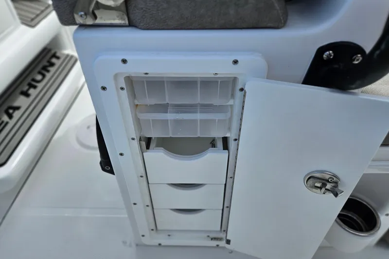 Slide: The Image of Storage compartment on 2026 Sea Hunt Ultra 245 SE boat with open drawers. - 15